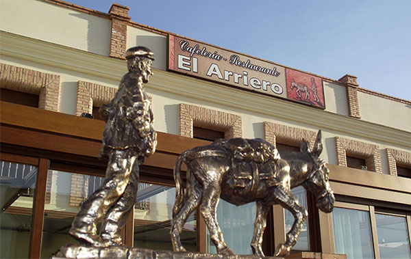 Estatua el Arriero con fachada hotel rural 'El arriero' de fondo